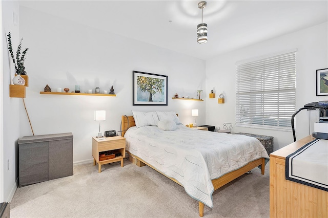 bedroom with baseboards and light colored carpet