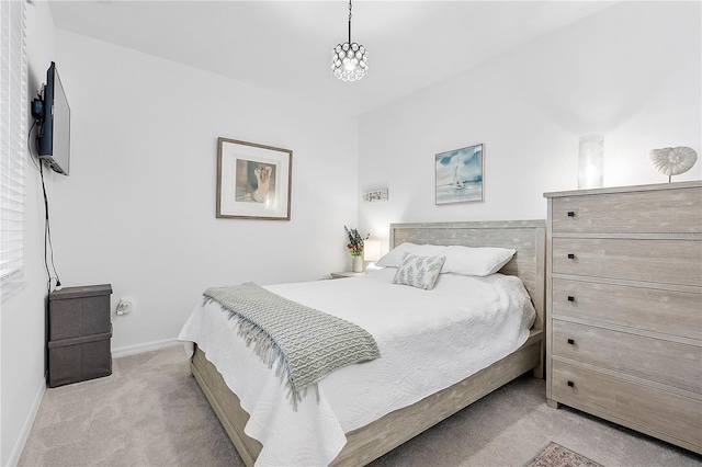 bedroom with carpet floors, an inviting chandelier, and baseboards