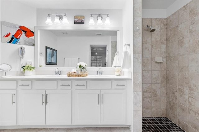 bathroom featuring double vanity, visible vents, a walk in shower, and a sink