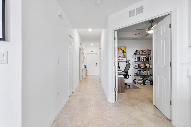 hall featuring light tile patterned floors, light carpet, visible vents, and baseboards