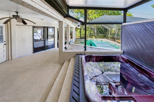 exterior space featuring glass enclosure, a patio area, and a ceiling fan