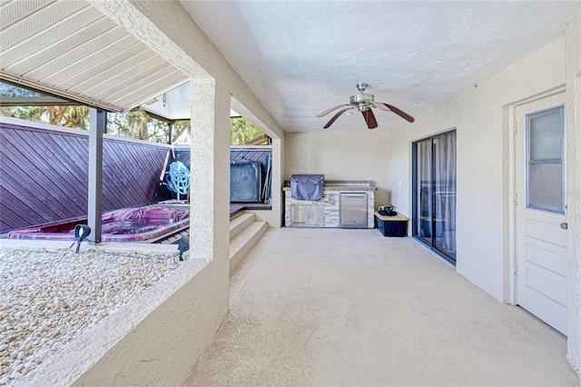 view of patio / terrace featuring exterior kitchen, ceiling fan, and fence