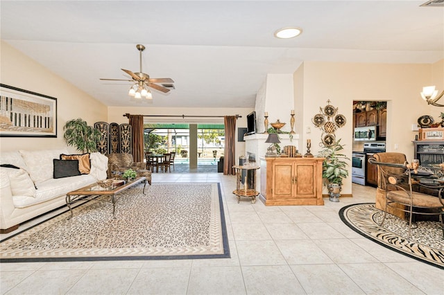 living area with lofted ceiling, light tile patterned floors, ceiling fan with notable chandelier, and visible vents