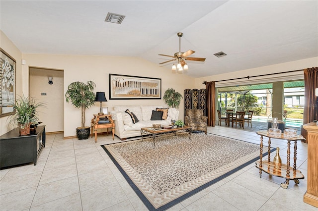 living room featuring lofted ceiling, tile patterned flooring, visible vents, and a ceiling fan