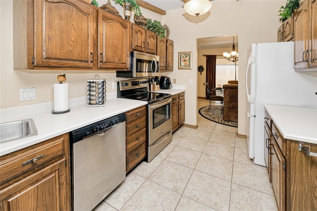 kitchen featuring appliances with stainless steel finishes, brown cabinets, light countertops, and light tile patterned floors