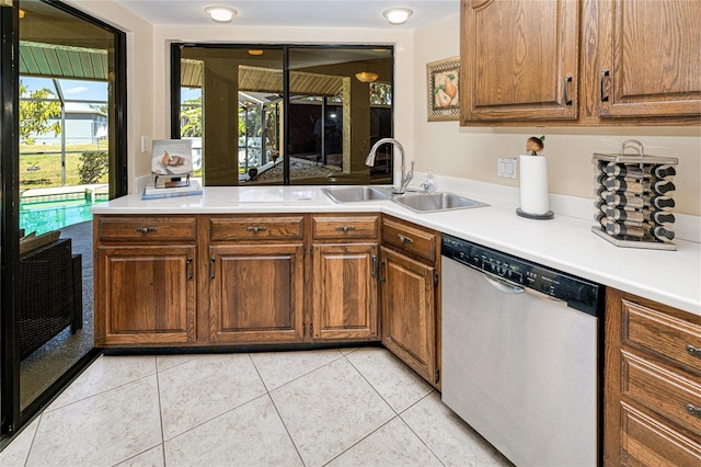 kitchen with brown cabinets, light tile patterned floors, light countertops, and dishwasher