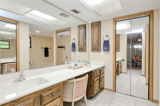 bathroom featuring double vanity, visible vents, a sink, and tile patterned floors