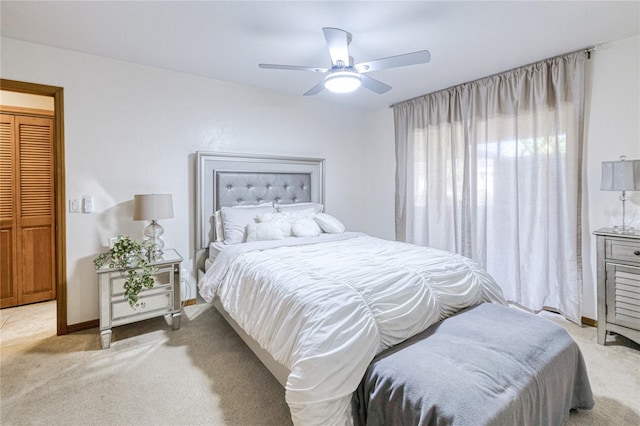 bedroom featuring light carpet, ceiling fan, and baseboards