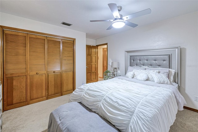 bedroom with light carpet, ceiling fan, visible vents, and a closet