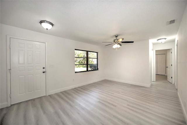 unfurnished room with a ceiling fan, light wood-type flooring, visible vents, and baseboards