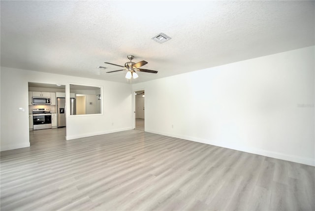 unfurnished living room with a ceiling fan, baseboards, visible vents, and light wood finished floors