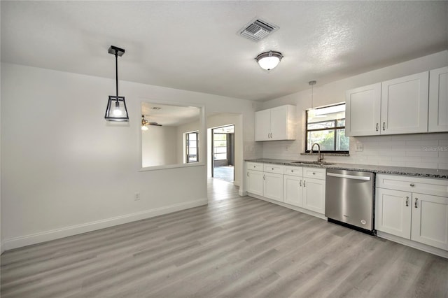 kitchen featuring light wood-style flooring, a sink, visible vents, decorative backsplash, and dishwasher