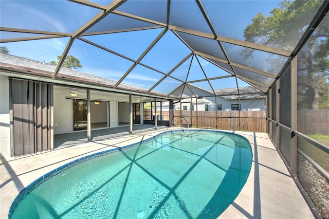 view of swimming pool featuring glass enclosure, a patio area, fence, and a fenced in pool