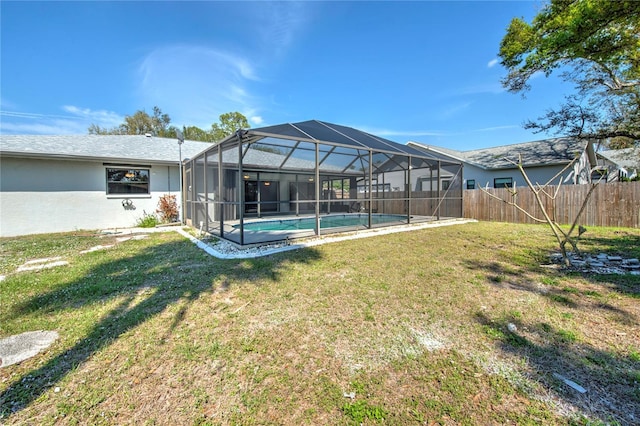 rear view of property featuring a fenced in pool, a yard, stucco siding, fence private yard, and a lanai