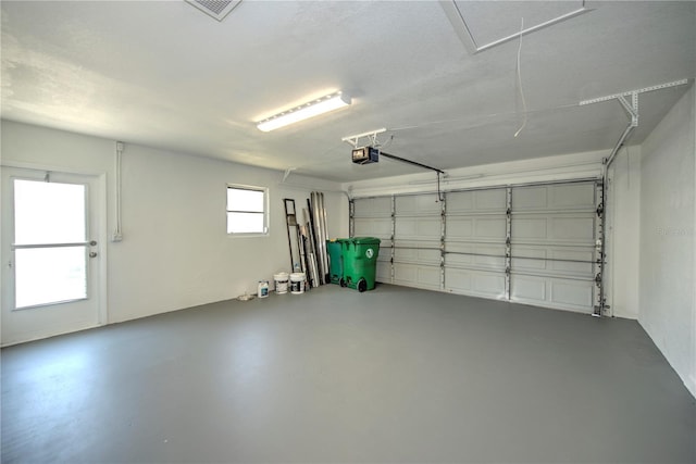 garage featuring a garage door opener and visible vents