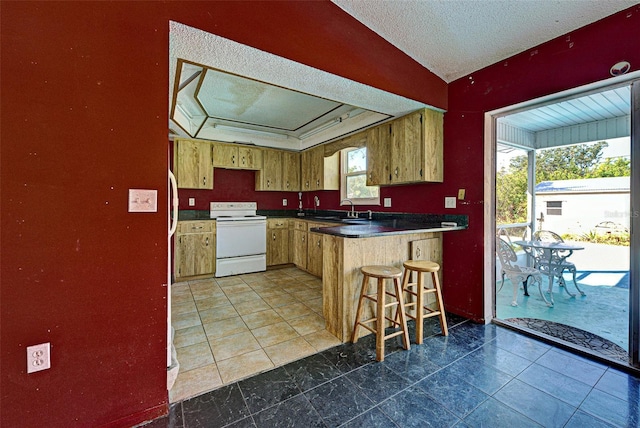 kitchen with a textured ceiling, a peninsula, a sink, electric stove, and dark countertops