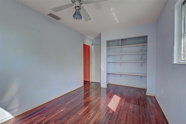 unfurnished bedroom with hardwood / wood-style floors, a closet, visible vents, and baseboards