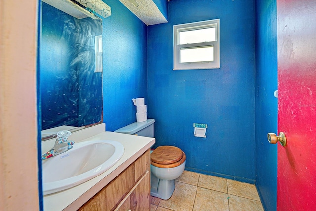 half bathroom with toilet, tile patterned flooring, and vanity