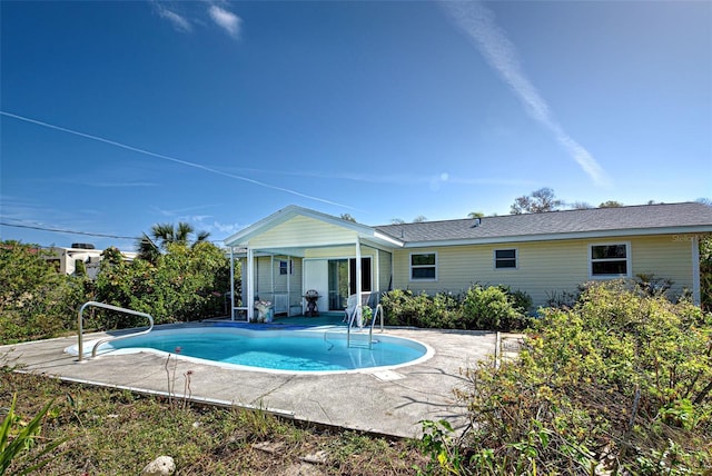 rear view of house with a patio area and an outdoor pool