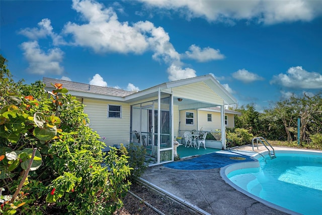 outdoor pool featuring a sunroom and a patio area