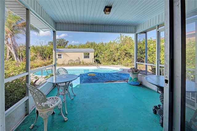 pool featuring a patio area and an outbuilding