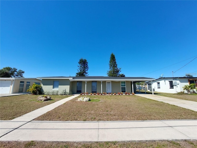 ranch-style home featuring driveway, a front lawn, a carport, and stucco siding