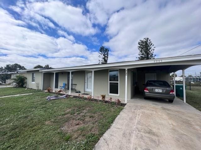 ranch-style house featuring a carport, concrete driveway, and a front lawn