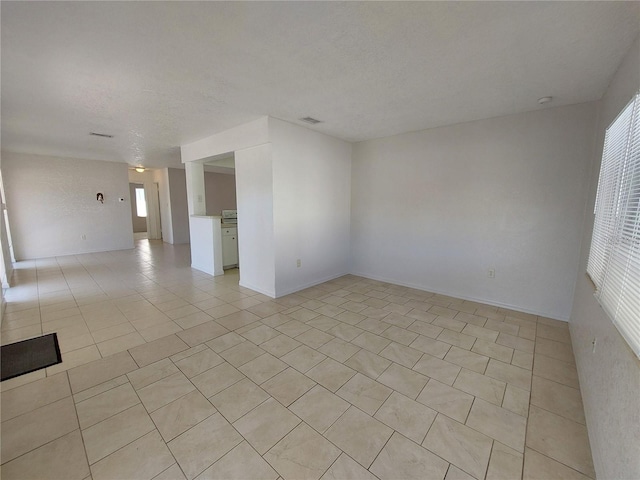 unfurnished room with light tile patterned floors, visible vents, and a textured ceiling