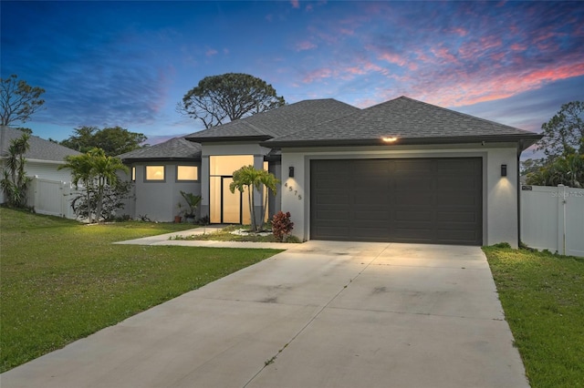 view of front facade featuring a garage, fence, a yard, concrete driveway, and stucco siding