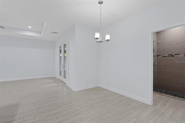 spare room featuring visible vents, baseboards, light wood-style flooring, an inviting chandelier, and recessed lighting