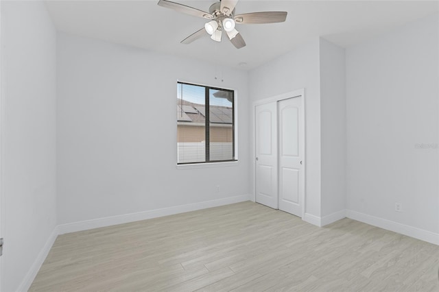 unfurnished bedroom with baseboards, a closet, and light wood-style floors