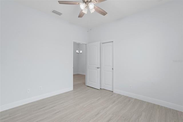 unfurnished room featuring light wood-style floors, visible vents, baseboards, and ceiling fan