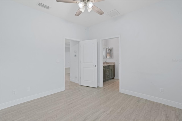 unfurnished bedroom featuring ensuite bathroom, light wood-style flooring, visible vents, and baseboards