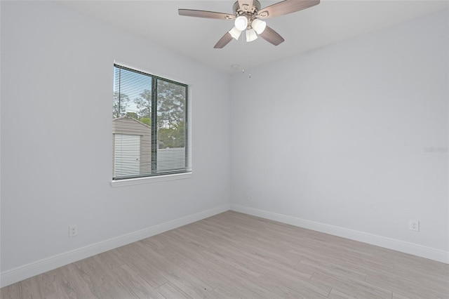 empty room featuring baseboards, a ceiling fan, and light wood-style floors