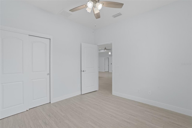 unfurnished bedroom with light wood finished floors, a closet, visible vents, and baseboards