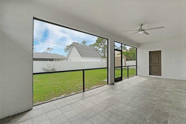 unfurnished sunroom with ceiling fan