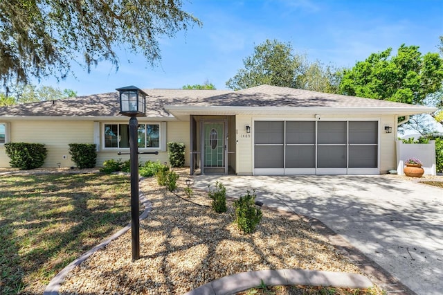 ranch-style house with driveway, a garage, and roof with shingles