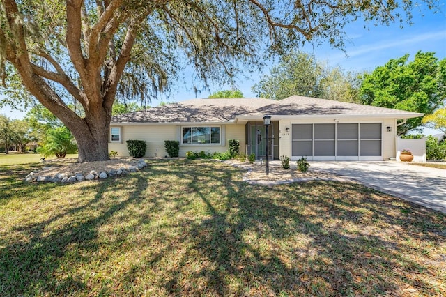 ranch-style home with concrete driveway, a garage, and a front lawn