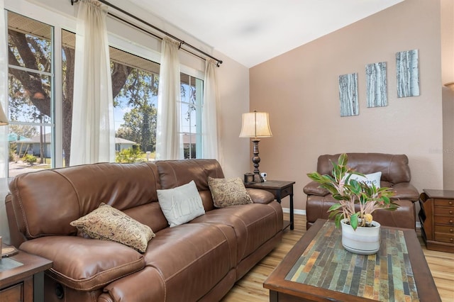 living room featuring light wood-type flooring and lofted ceiling