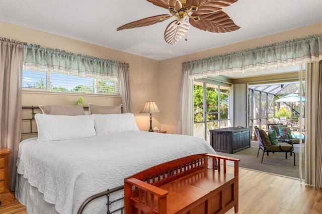 bedroom with access to exterior, multiple windows, ceiling fan, and light wood finished floors