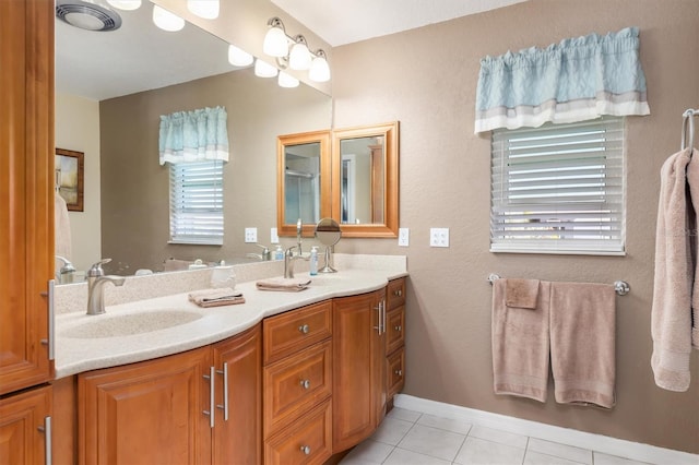 full bath with tile patterned flooring, double vanity, plenty of natural light, and a sink