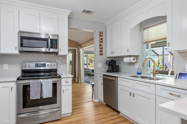 kitchen with white cabinets, visible vents, appliances with stainless steel finishes, and a sink