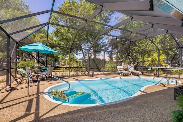 pool featuring glass enclosure and a patio area