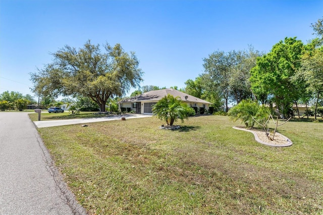 view of front of home featuring a front lawn, a garage, and driveway