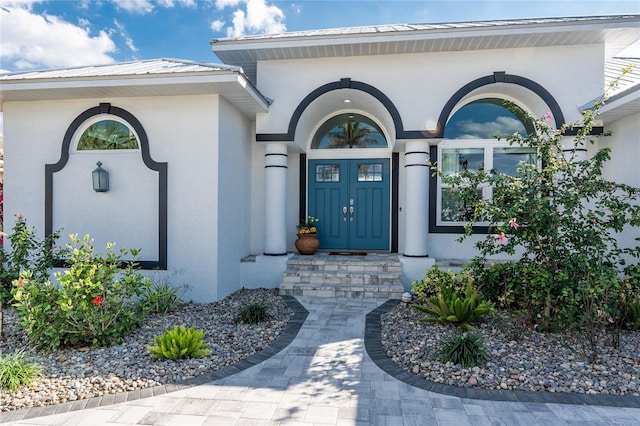 entrance to property with metal roof and stucco siding