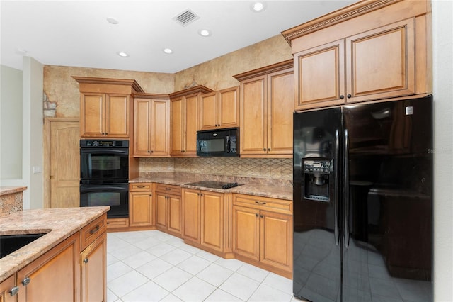 kitchen with light stone counters, tasteful backsplash, recessed lighting, visible vents, and black appliances