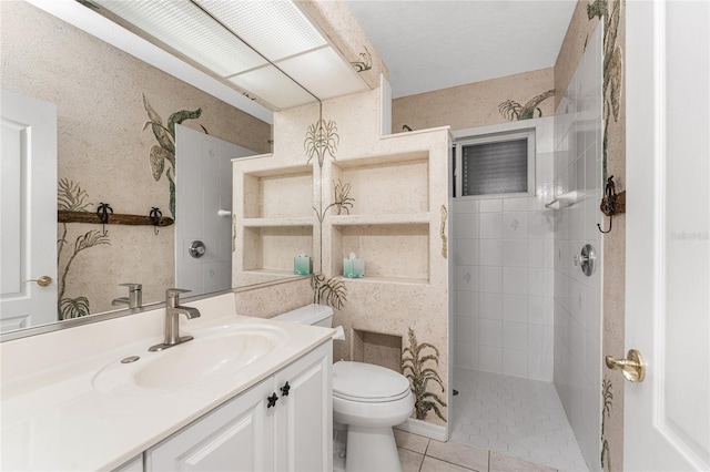 full bathroom featuring toilet, tile patterned flooring, a tile shower, and vanity