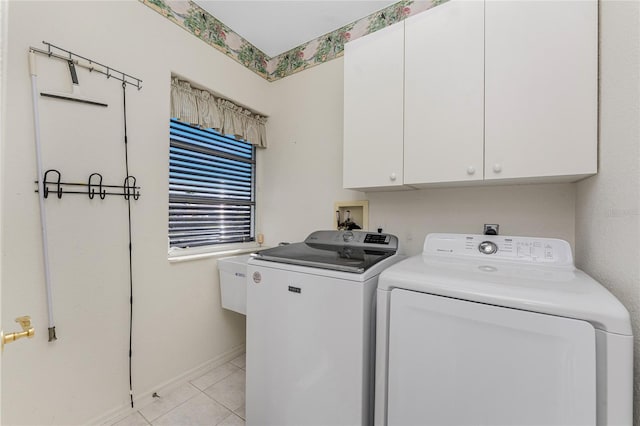 washroom with washer and dryer, cabinet space, and light tile patterned flooring