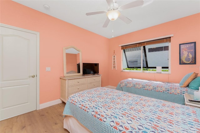 bedroom featuring wood finished floors, a ceiling fan, and baseboards