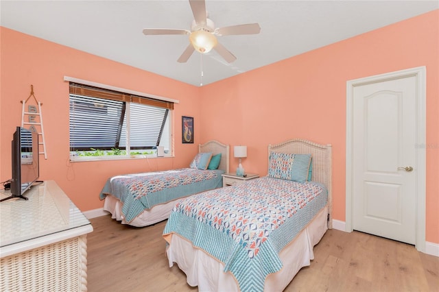 bedroom with a ceiling fan, baseboards, and wood finished floors